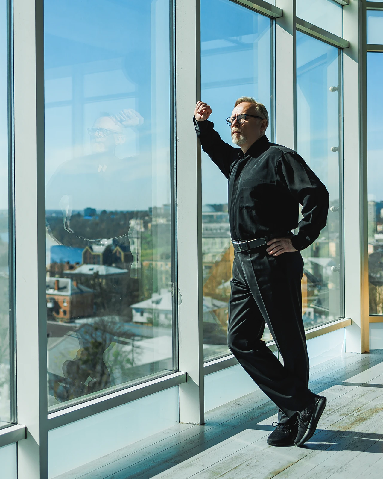 Mann steht am Fenster und blickt hinaus